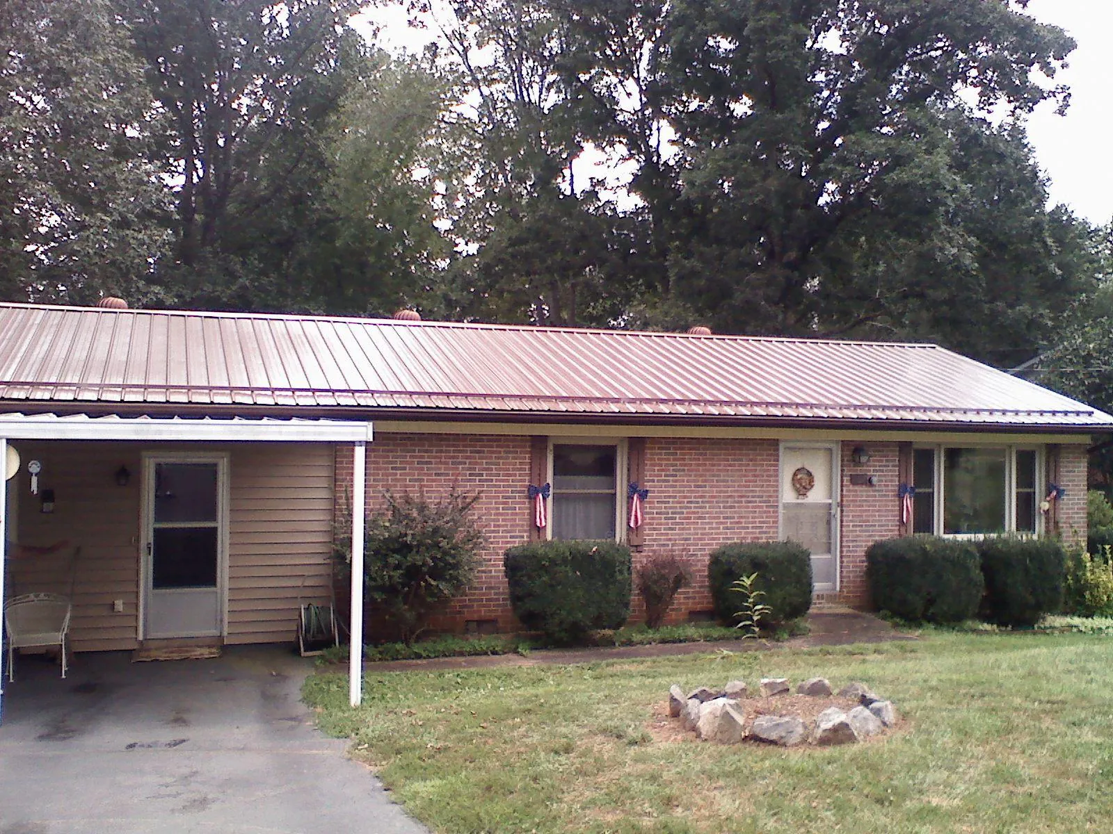 Bronze metal roof and carport on a brick ranch home in Sand Lake